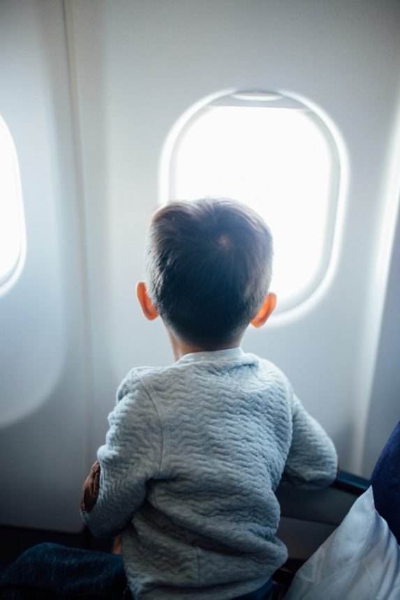 child stares out airplane window