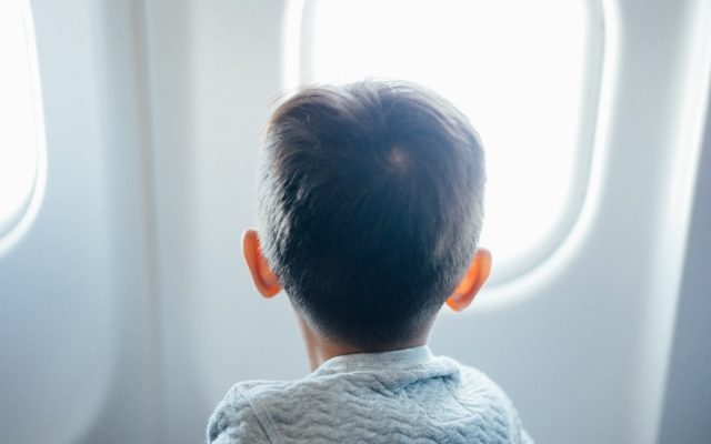 child stares out airplane window